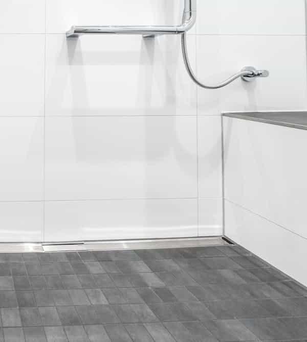 Von der Seite gezeigte moderne Sitzmöglichkeit von einem neuen barrierefreien Bad von Steinkühler in Leverkusen.