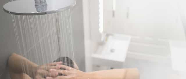 Frau duscht in ihrem individuell gestalteten durch eine Komplettbad Sanierung von Steinkühler in Leverkusen.