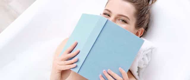 Frau liegt mit einem Buch in ihrer neuen Badewanne von Steinkühler in Leverkusen