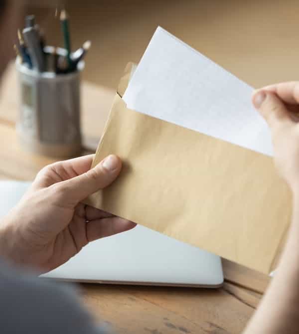 Mann öffnet Zehn-Jahres-Schutzbrief der Heizanlage von Steinkühler in Leverkusen.