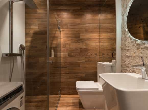 Kleines Bad mit Holzoptik in der Dusche von Steinkühler.