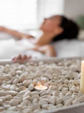 Frau entspannt bei Kerzenlicht in neuer Badewanne Dank Teilbad Modernisierung von Steinkühler in Leverkusen.